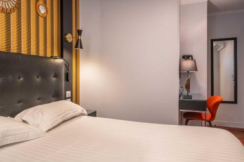 a bedroom with a bed and a chair and a desk at Hotel Marena in Paris