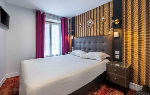 Un dormitorio con una cama grande y una ventana en Hotel Marena, en París