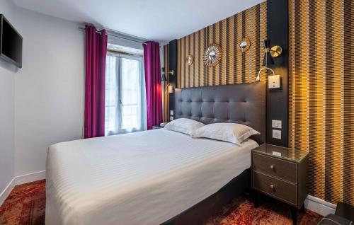 a bedroom with a large bed and a window at Hotel Marena in Paris