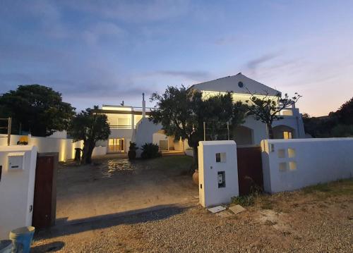 a white house with a fence in front of it at Itanco Resort in Crotone
