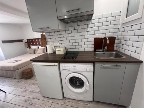 une cuisine avec une machine à laver et un évier dans l'établissement A 2 minutes du port, à Saint-Tropez