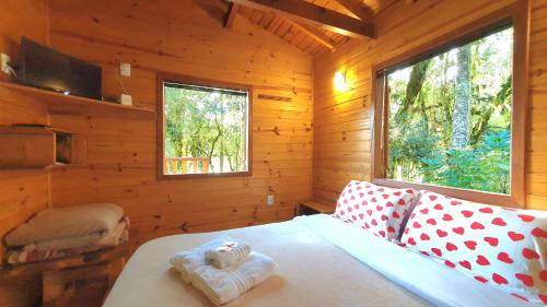 a bedroom with a bed in a wooden cabin at Pousada Vale da Imbuia chalé para temporada in Urubici