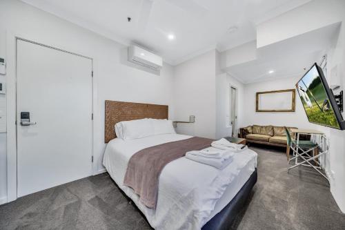 sypialnia z dużym łóżkiem i telewizorem w obiekcie Grosvenor 3121 Richmond w Melbourne