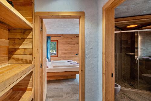 um quarto com uma cama e uma casa de banho com um chuveiro em Tana del picchio Nero em Falcade