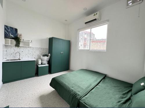 a bedroom with a green bed and a sink at B-HOMEAWAY in Ho Chi Minh City