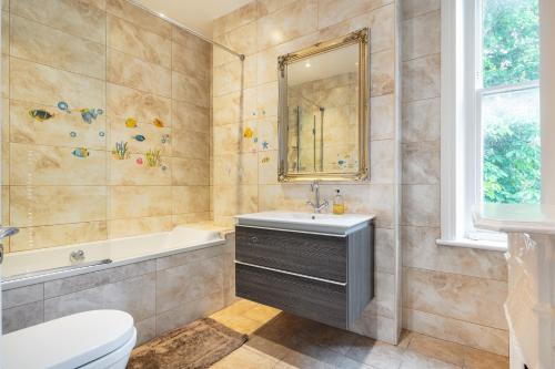 La salle de bains est pourvue d'un lavabo, d'une baignoire et de toilettes. dans l'établissement Stylish flat in Hampstead, à Londres