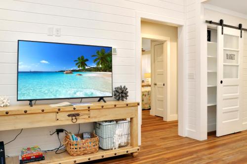 a living room with a flat screen tv on a wall at The Surf Ranch by Pristine Properties Vacation Rentals in Port Saint Joe