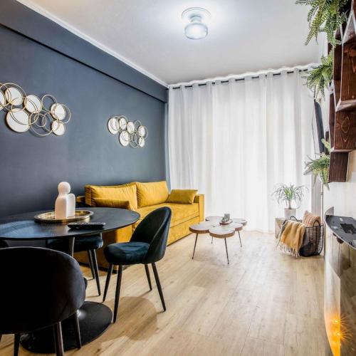 ein Wohnzimmer mit einem gelben Sofa und einem Tisch in der Unterkunft Classy Apartment in Athens in Athen