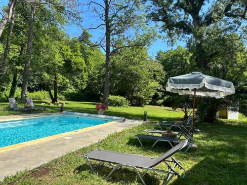 - une piscine avec 2 chaises longues et un parasol dans l'établissement Gîtes Terra di a Bravona, à Linguizzetta