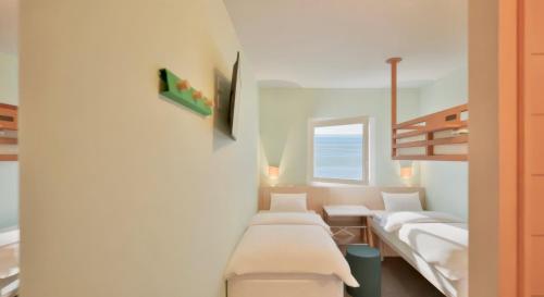 Habitación con 4 camas y ventana en Greet Hotel Nice Aéroport Promenade des Anglais en Niza