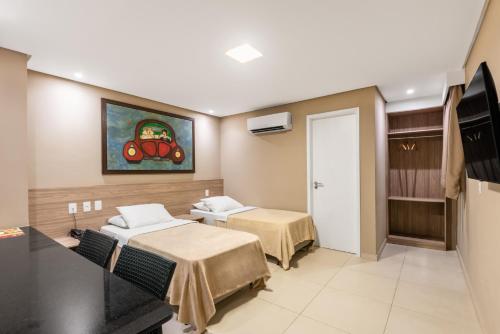 um quarto com duas camas e um quadro na parede em NovoHotell Recife no Recife