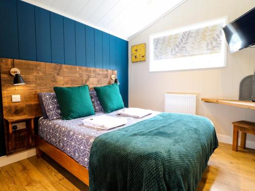 um quarto com uma cama com almofadas verdes em Hazel em Swadlincote
