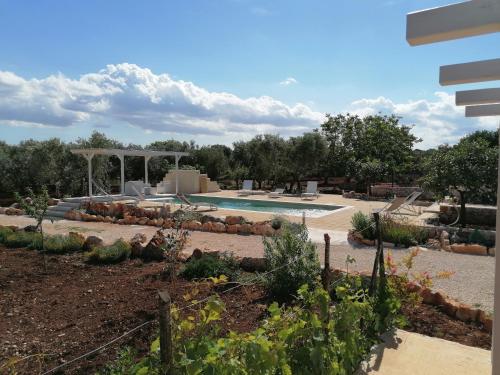 um jardim com uma piscina e um gazebo em Trullo del Sol em Ceglie Messapica