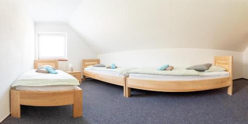 two twin beds in a room with at Penzion u můstku Jiřího Rašky in Trojanovice