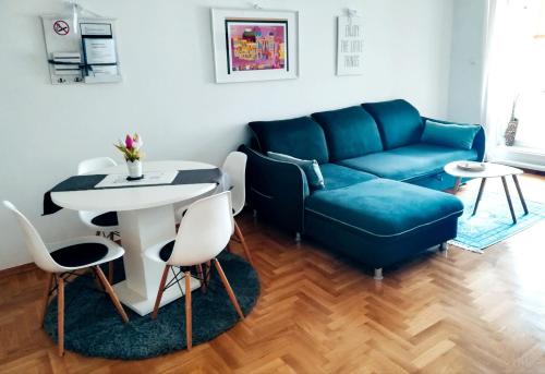 ein Wohnzimmer mit einem blauen Sofa und einem Tisch in der Unterkunft Apartment Angelus in Zagreb