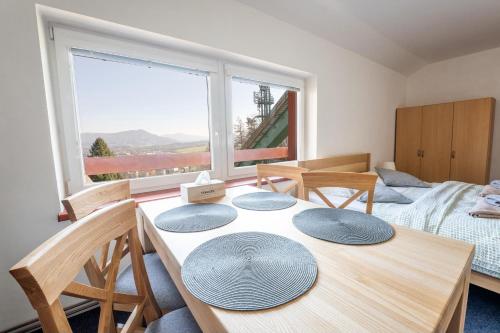 a room with a table and chairs and a window at Penzion u můstku Jiřího Rašky in Trojanovice