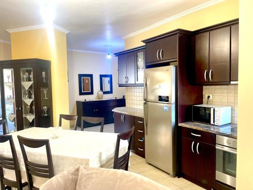 a kitchen with a table and a kitchen with a microwave at Ernest Apartments in Sarandë