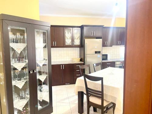 a kitchen with a table and chairs and a refrigerator at Ernest Apartments in Sarandë