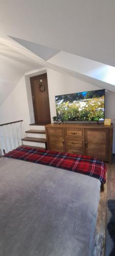 a bedroom with a flat screen tv on a dresser at Studio Casa Mia in Câmpulung Moldovenesc