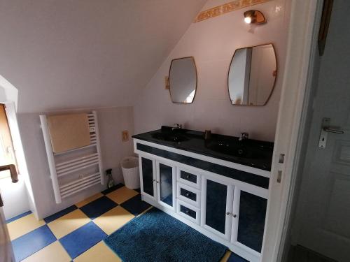 une salle de bain avec un lavabo noir et deux miroirs dans l'établissement TY STEMIDOR, à Langolen