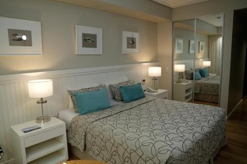 1 dormitorio con cama con almohadas azules y espejo en Hotel Metropolitano Supara en Buenos Aires