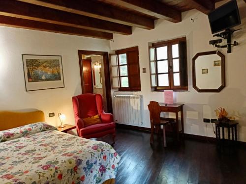 una camera con letto, sedia e scrivania di Le Petit Chateau a Vezzi Portio