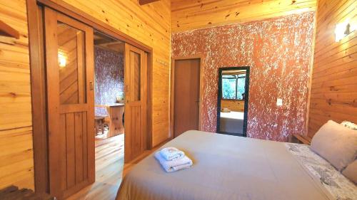 a bedroom with a bed with two towels on it at Pousada Vale da Imbuia chalé para temporada in Urubici