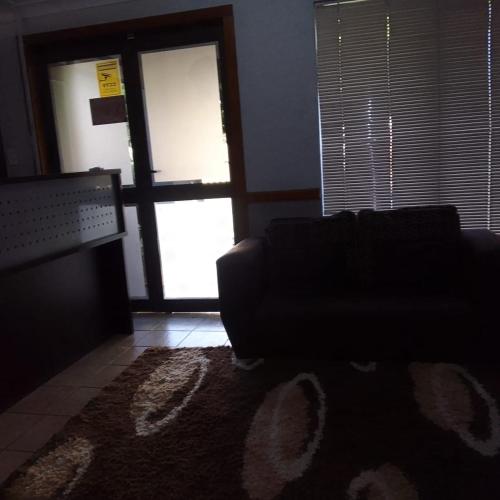 a living room with a couch and a window at The Best Moments guesthouse in Rustenburg