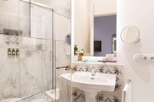 a bathroom with a sink and a shower at Hotel Tayko Sevilla in Seville