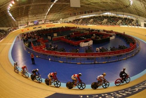 a group of people riding bikes on a track in an arena at Bluesea Home near Etihad in Manchester