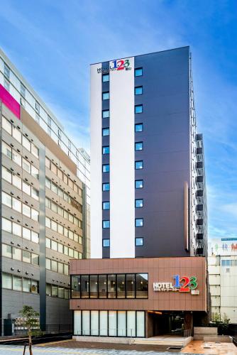 a tall building with a sign in front of it at Hotel 1-2-3 Fukuyama in Fukuyama