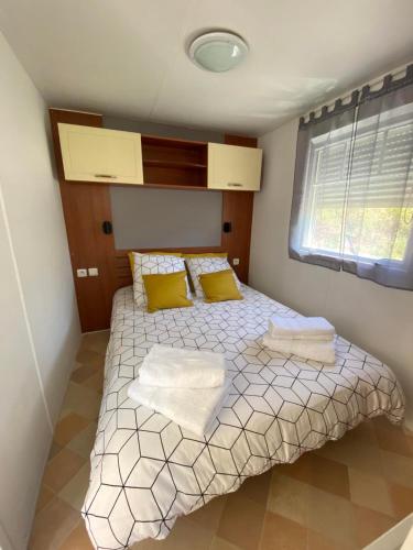 - une petite chambre avec un lit et des oreillers jaunes dans l'établissement Mobil Home, à Tralonca