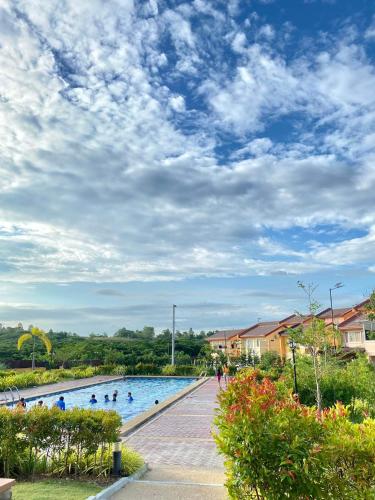 a swimming pool with people in it under a cloudy sky at Camella homes near Davao Airport in Davao City