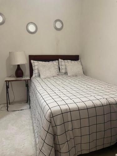 um quarto com uma cama e uma mesa com um candeeiro em hermosa casa en la zona colonial em Santo Domingo