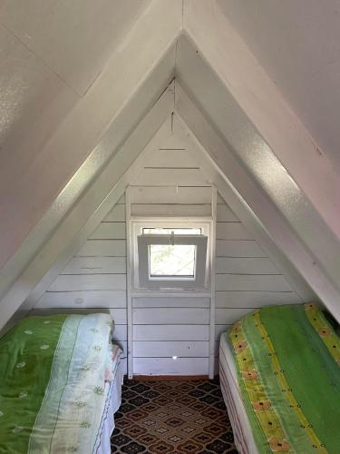a small room with two beds in a attic at SZAŁASY drewniane nad rzeką BIEBRZA in Goniadz