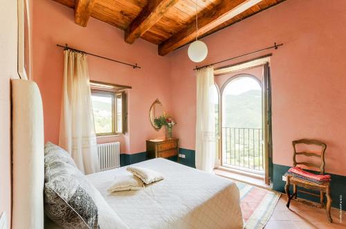 a bedroom with a bed and a large window at Castello Di Postignano Relais in Sellano