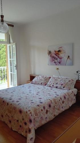 - une chambre dotée d'un lit avec un couvre-lit floral dans l'établissement villetta le palme, à Toscolano Maderno