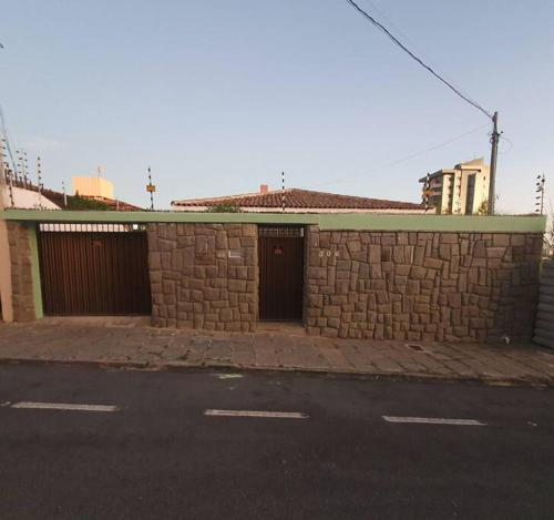 ein Backsteingebäude mit zwei Garagentüren auf einer Straße in der Unterkunft locação de casa no Jardim Tavares por diária. in Campina Grande