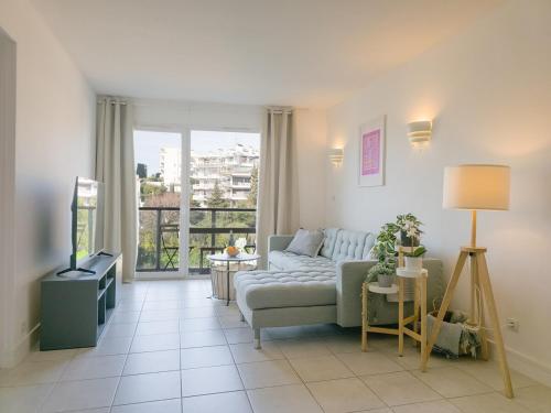 un salon avec un canapé et une télévision dans l'établissement A022 Chic Cannes Flat Balcony Parking, à Cannes