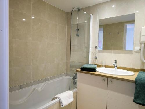 une salle de bain avec une baignoire, un lavabo et un miroir dans l'établissement A022 Chic Cannes Flat Balcony Parking, à Cannes
