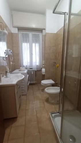 a bathroom with two toilets and a sink and a shower at Battisti in Pavia