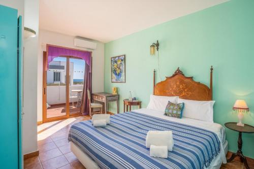 een slaapkamer met een groot bed met een blauw en wit gestreepte deken bij Alvor Ar de Mar in Alvor