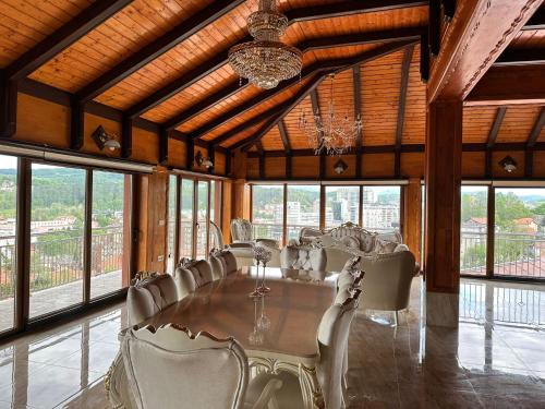 a large room with a table with chairs and a chandelier at Lux Villa Emina in Tuzla