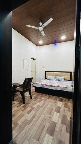 1 dormitorio con 1 cama, 1 silla y ventilador de techo en Hotel Amrit shree, en Ujjain