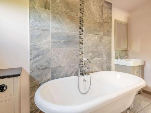 La salle de bains est pourvue d'une baignoire blanche et d'un lavabo. dans l'établissement 2 Bed in Sherwood Forest 88429, 