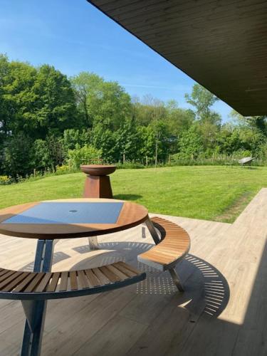 a wooden bench sitting on a deck with a field at VAKANTIEDOMEIN DOUVE in Heuvelland