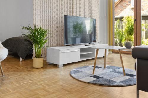 ハーゼリュンネにあるSuiten - Appartement by Studio Livingの白いキャビネットの上にテレビが置かれたリビングルーム