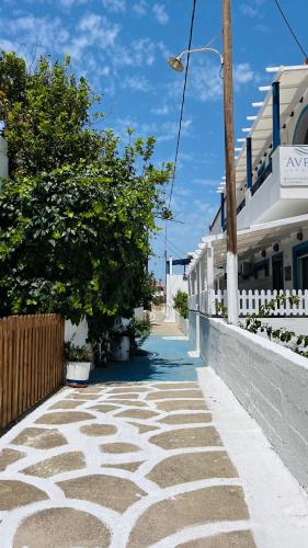an empty street with trees and a building at Avra Studios in Elafonisos