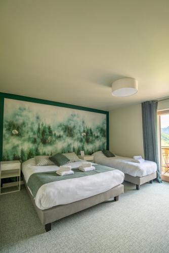 two beds in a room with a large painting on the wall at Hotel Le Bois Joli in Bernex