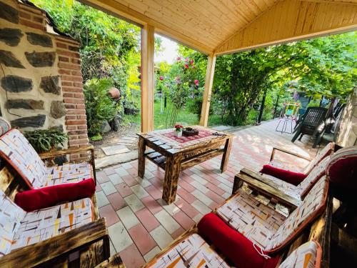 a screened in porch with a table and chairs at Guest house poligloti in Tʼelavi